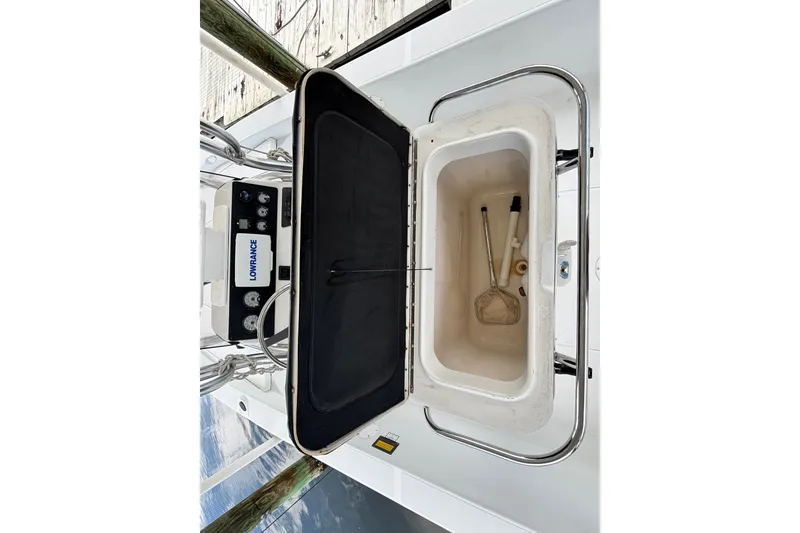 Slide: The Image of Open storage compartment on 2002 Ranger 2300 Bay Ranger boat with fishing tools inside. - 22
