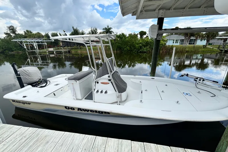The Image of 2002 Ranger 2300 Bay Ranger boat docked by a serene waterfront. - 1