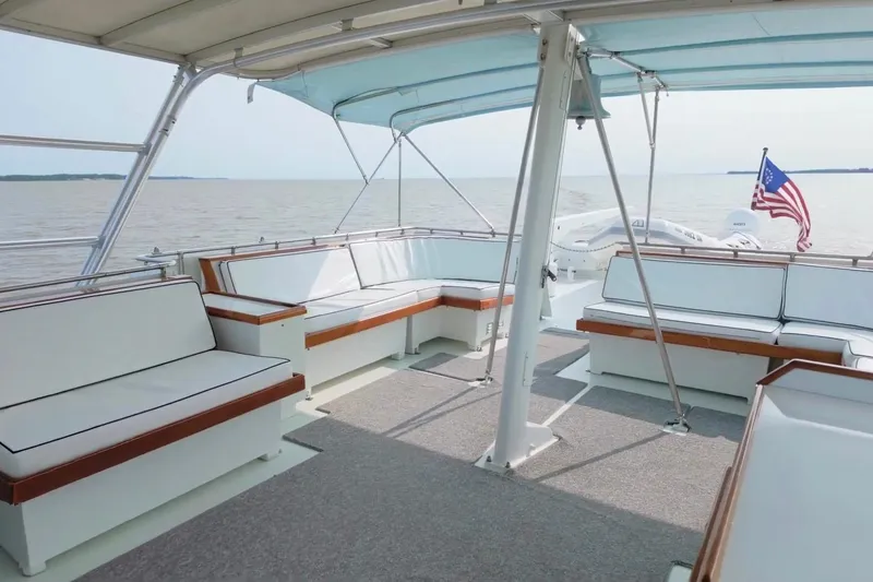 Slide: The Image of Spacious deck of 1980 Hatteras 70 Motor Yacht with seating and American flag. - 18