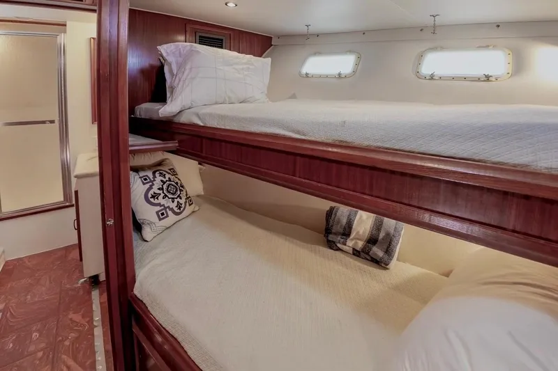 Slide: The Image of Bunk beds in 1980 Hatteras 70 Motor Yacht cabin with wooden accents and porthole windows. - 26