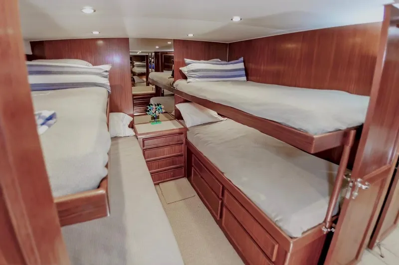 Slide: The Image of Cozy cabin with bunk beds in 1980 Hatteras 70 Motor Yacht, featuring wood paneling. - 23