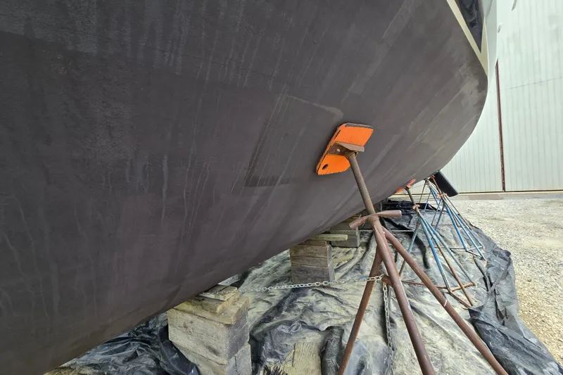 Slide: The Image of 1980 Hatteras 70 Motor Yacht hull supported on stands in a boatyard. - 32