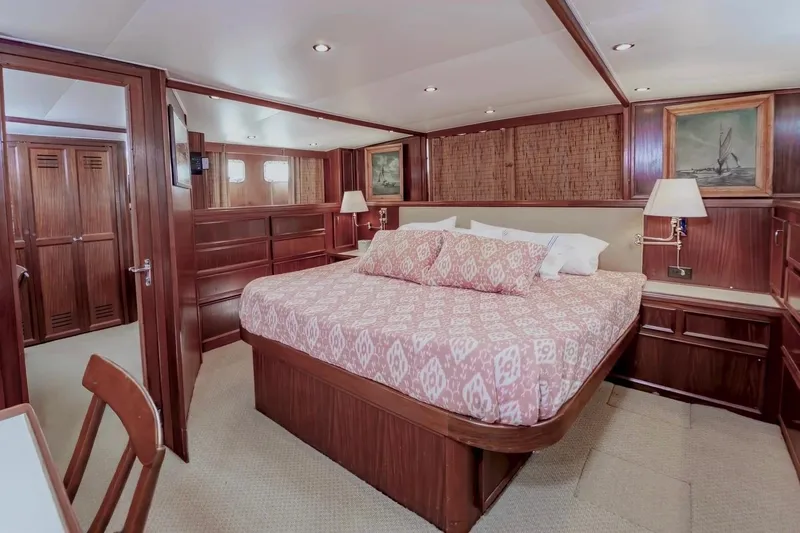 Slide: The Image of Luxurious 1980 Hatteras 70 Motor Yacht bedroom with elegant wood paneling and cozy bedding. - 21