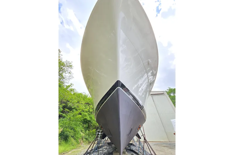 Slide: The Image of 1980 Hatteras 70 Motor Yacht on dry dock, showcasing sleek hull design. - 30