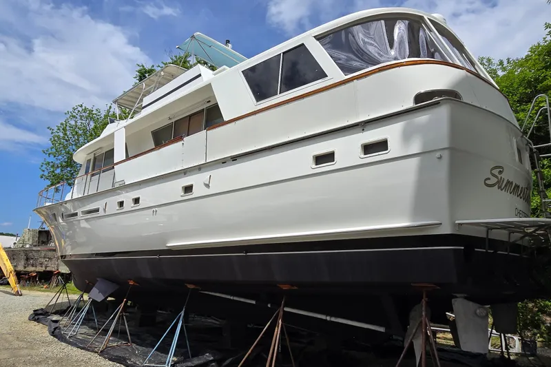Slide: The Image of 1980 Hatteras 70 Motor Yacht on stands, white exterior, clear sky background. - 46