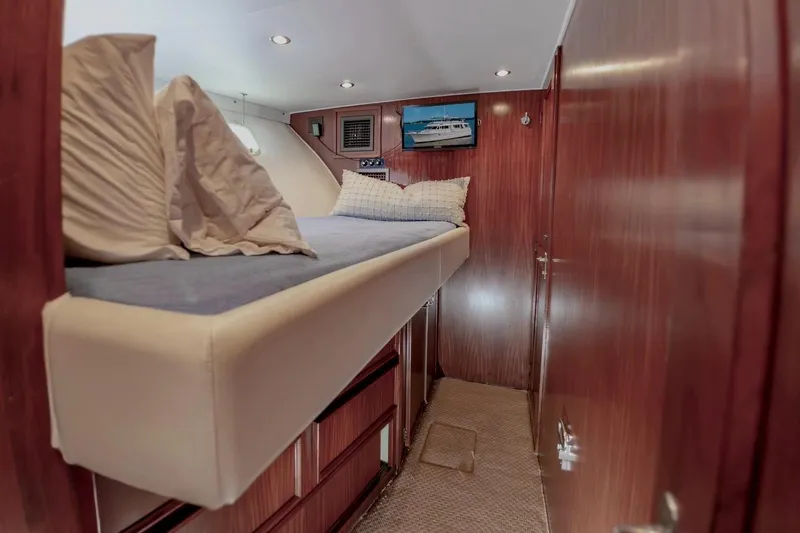 Slide: The Image of Cozy cabin interior of 1980 Hatteras 70 Motor Yacht with wooden paneling and bed. - 25