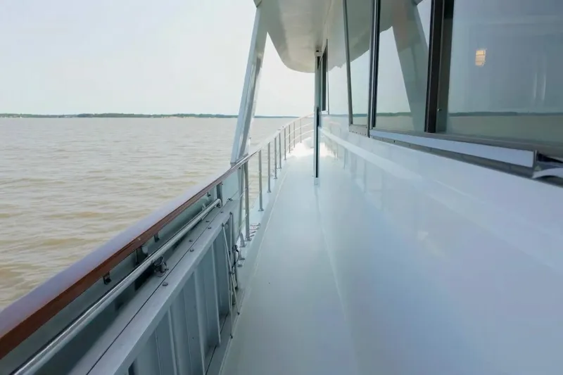 Slide: The Image of Side deck view of 1980 Hatteras 70 Motor Yacht on calm waters. - 15