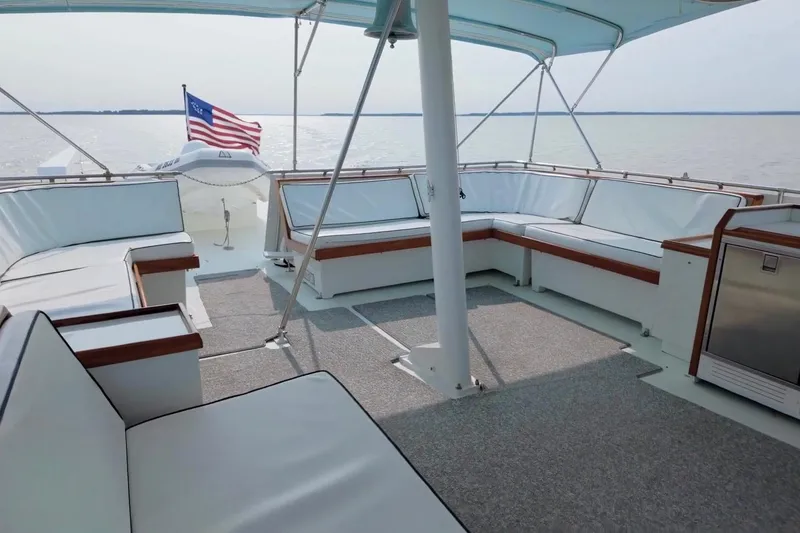 Slide: The Image of Spacious deck of 1980 Hatteras 70 Motor Yacht with seating and American flag. - 19