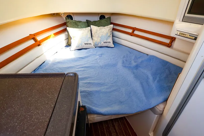 Slide: The Image of Cozy cabin interior of 2015 Grady-White Sailfish 282 with blue bedding and pillows. - 37