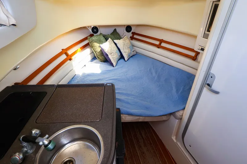 Slide: The Image of 2015 Grady-White Sailfish 282 cabin interior with bed, sink, and cozy decor. - 29