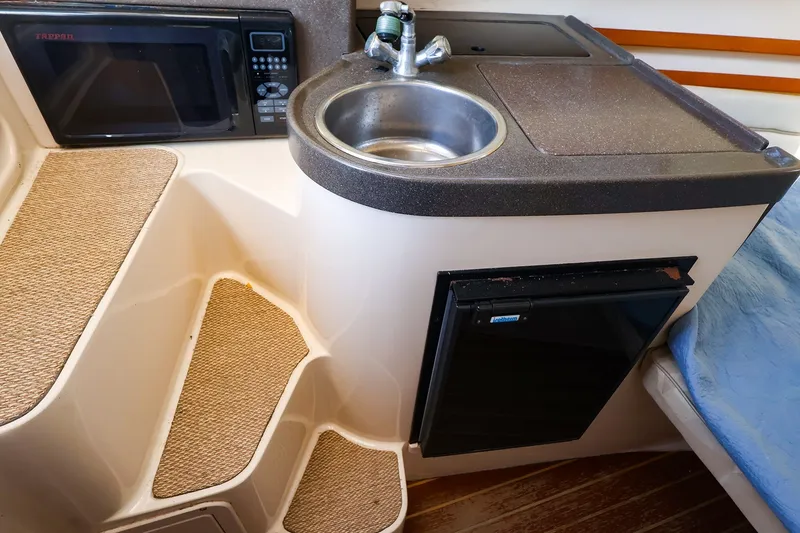 Slide: The Image of Compact kitchenette in 2015 Grady-White Sailfish 282 with sink, microwave, and mini-fridge. - 31