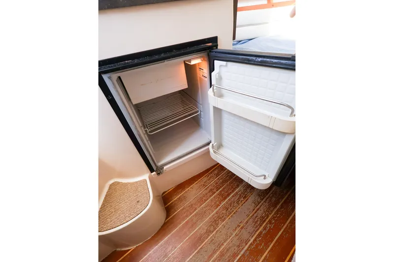 Slide: The Image of Open refrigerator inside 2015 Grady-White Sailfish 282 boat, showcasing interior storage space. - 34