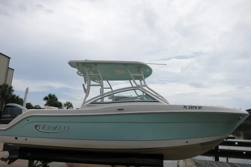 Slide: The Image of 2020 Robalo R247 Dual Console boat with sleek design, docked under cloudy sky. - 2