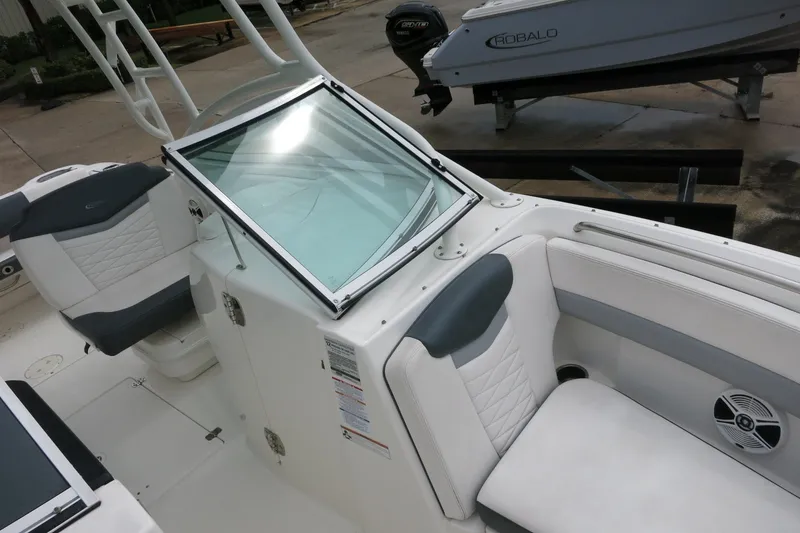 Slide: The Image of 2020 Robalo R247 Dual Console boat interior with white seating and windshield. - 25