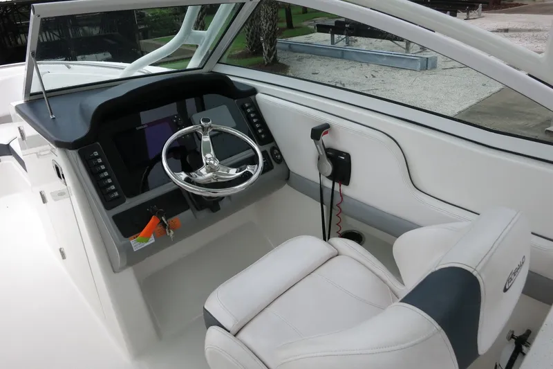 Slide: The Image of 2020 Robalo R247 Dual Console boat cockpit with steering wheel and control panel. - 18