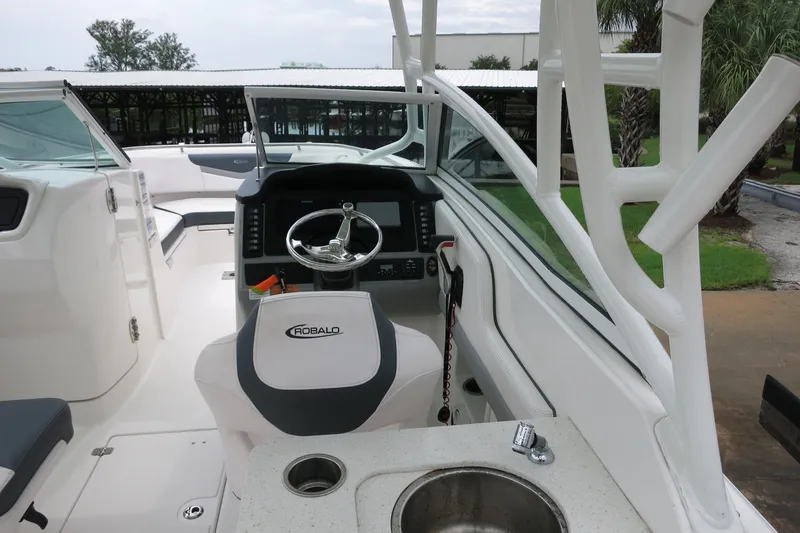Slide: The Image of 2020 Robalo R247 Dual Console boat interior with steering wheel and sink. - 13