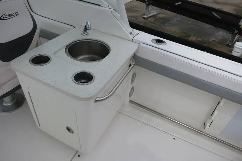 Slide: The Image of 2020 Robalo R247 Dual Console boat interior with sink and seating area. - 11