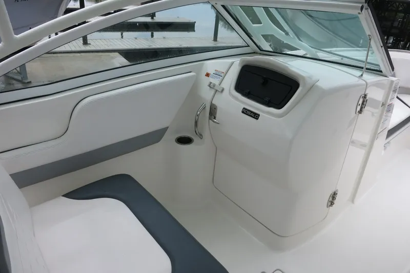 Slide: The Image of 2020 Robalo R247 Dual Console boat interior with white seating and storage compartment. - 19