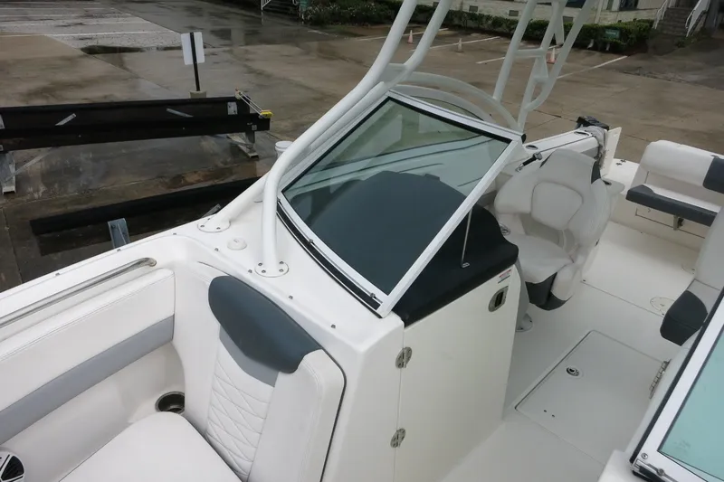 Slide: The Image of 2020 Robalo R247 Dual Console boat interior with white seating and windshield. - 26