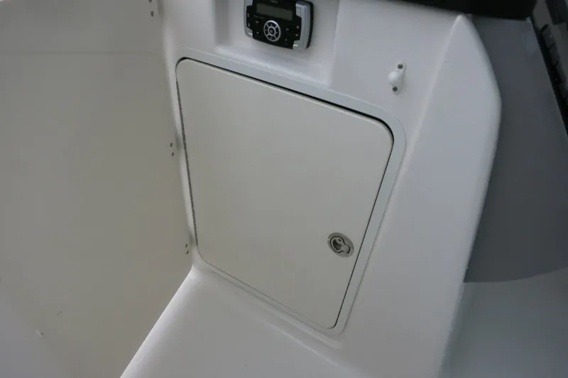 Slide: The Image of 2020 Robalo R247 Dual Console boat storage compartment with control panel. - 27