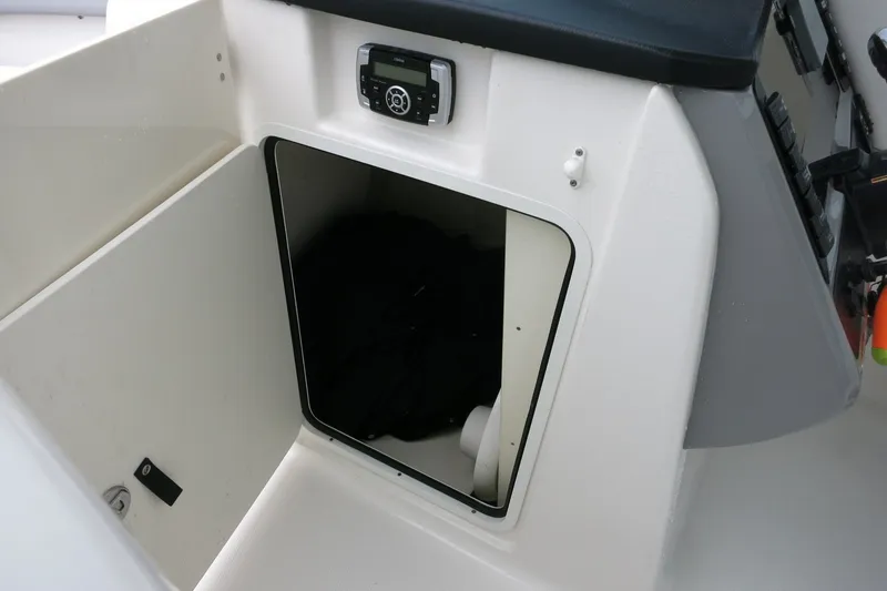 Slide: The Image of 2020 Robalo R247 Dual Console boat storage compartment with control panel. - 28