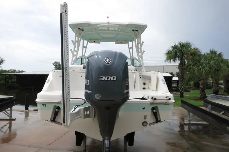 Slide: The Image of 2020 Robalo R247 Dual Console boat with Yamaha 300 engine, docked near palm trees. - 4