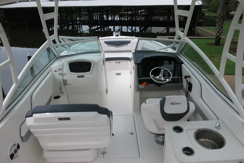 Slide: The Image of 2020 Robalo R247 Dual Console boat interior with helm, seating, and sink. - 14