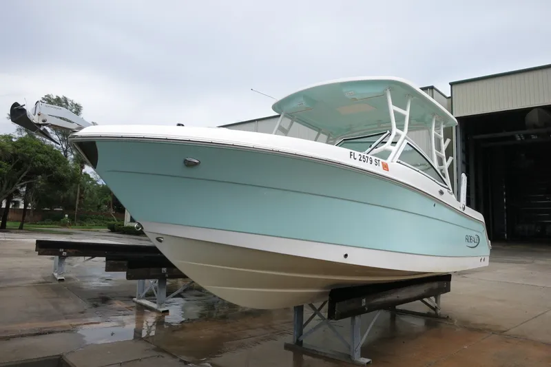 Slide: The Image of 2020 Robalo R247 Dual Console boat on display in a marina setting. - 6
