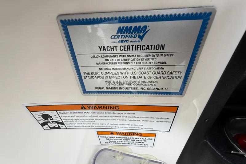 Slide: The Image of NMMA certified yacht certification and safety warnings on a 2016 Regal 2700 ES Bowrider. - 24