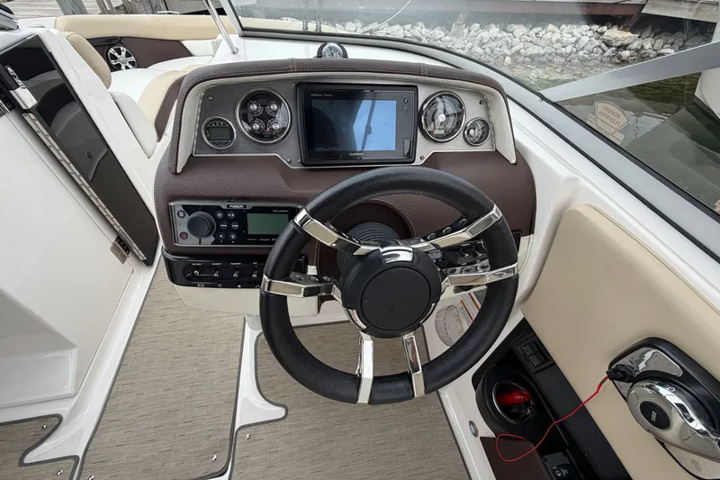 Slide: The Image of Steering console of a 2016 Regal 2700 ES Bowrider with modern controls and gauges. - 17