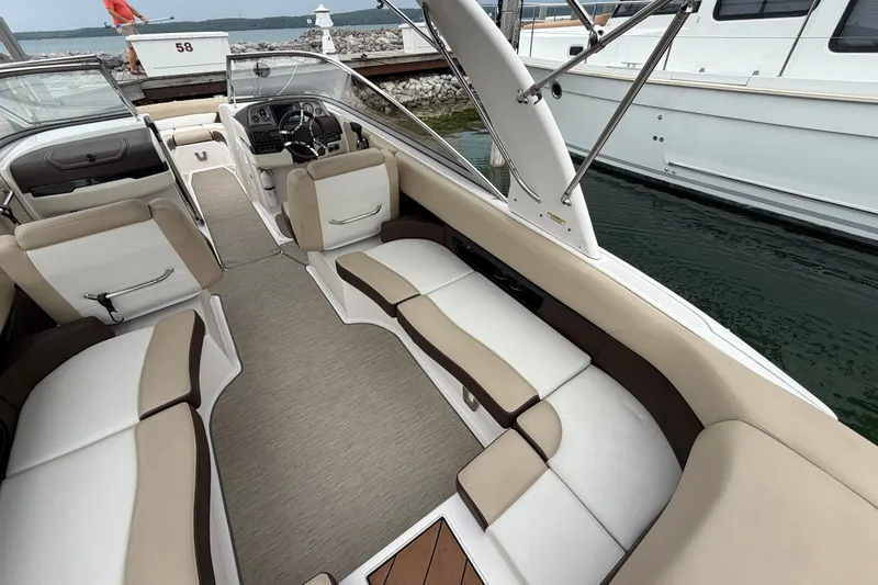 Slide: The Image of 2016 Regal 2700 ES Bowrider interior with beige seating and sleek design at dock. - 14