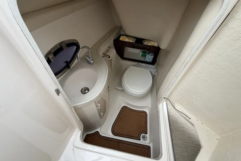 Slide: The Image of 2016 Regal 2700 ES Bowrider boat bathroom with sink, toilet, and storage. - 20