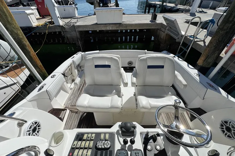 Slide: The Image of 2004 Sunseeker Sportfisher 37 cockpit with dual seats and control panel at dock. - 67