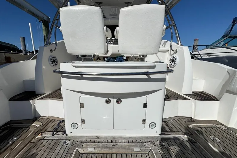 Slide: The Image of 2004 Sunseeker Sportfisher 37 boat interior with white seating and wooden deck. - 16