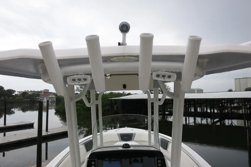 Slide: The Image of 2022 Robalo R230 Center Console boat with rod holders and electronics, docked by calm waters. - 8