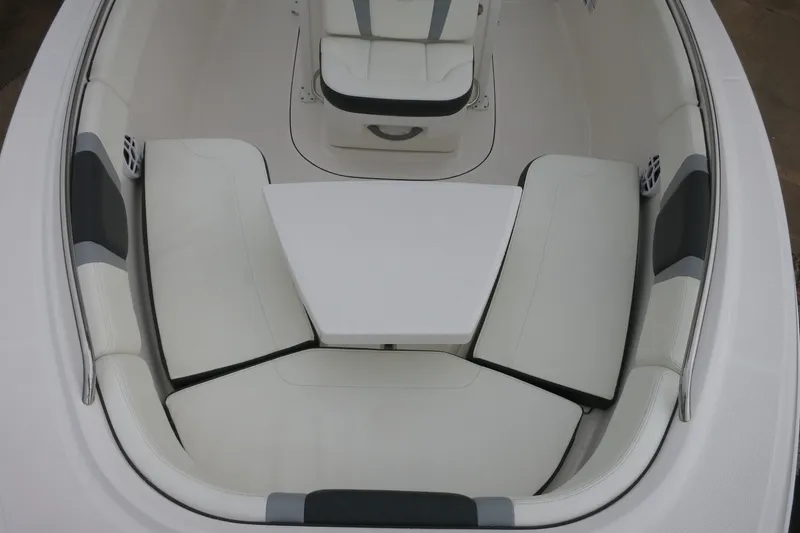 Slide: The Image of 2022 Robalo R230 Center Console boat interior with cushioned seating and table. - 16