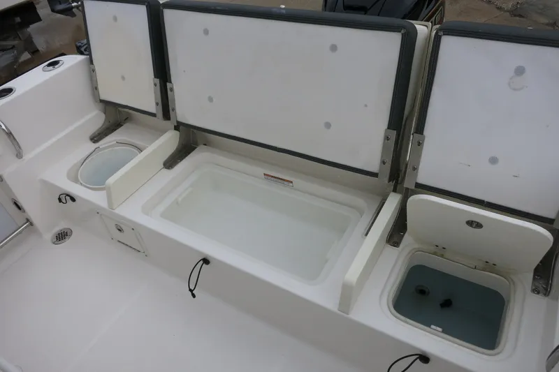 Slide: The Image of 2022 Robalo R230 Center Console boat with open storage compartments and livewell. - 11
