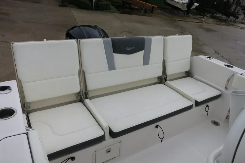 Slide: The Image of 2022 Robalo R230 Center Console boat seating area with white cushioned seats. - 10