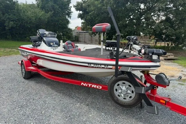 Slide: The Image of 2008 Nitro Z-7 boat on red trailer, parked on gravel, surrounded by trees. - 5