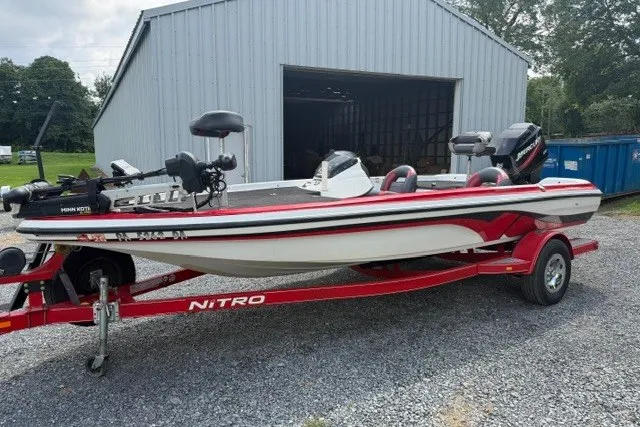 The Image of 2008 Nitro Z-7 boat on red trailer, parked outside a metal building. - 2