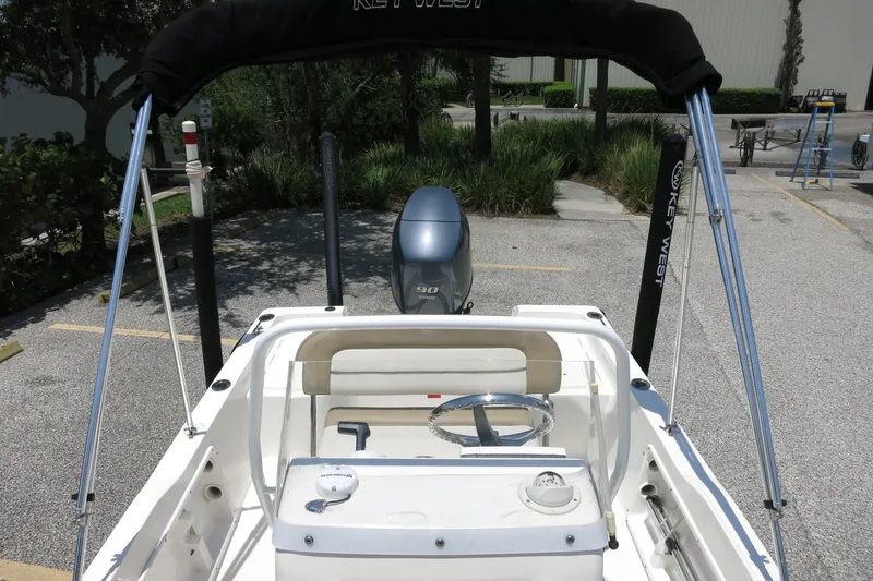 Slide: The Image of 2016 Key West 1720 Center Console boat with canopy and outboard motor in parking lot. - 31