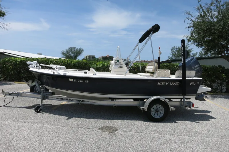 Slide: The Image of 2016 Key West 1720 Center Console boat on trailer, parked outdoors. - 2