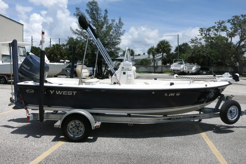 Slide: The Image of 2016 Key West 1720 Center Console boat on trailer, parked outdoors under a clear sky. - 19