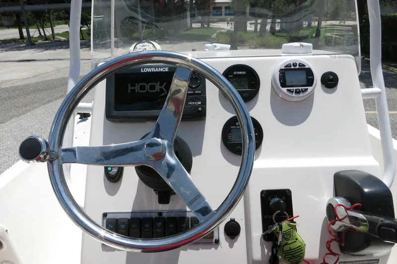 Slide: The Image of 2016 Key West 1720 Center Console boat dashboard with steering wheel and navigation instruments. - 36