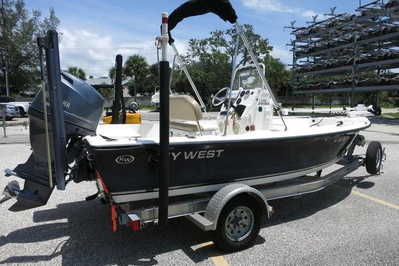 Slide: The Image of 2016 Key West 1720 Center Console boat on trailer, parked outdoors under clear sky. - 18