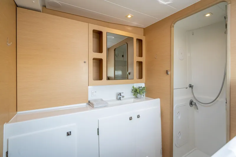 Slide: The Image of The image shows a modern boat bathroom with wood paneling and a shower. - 38