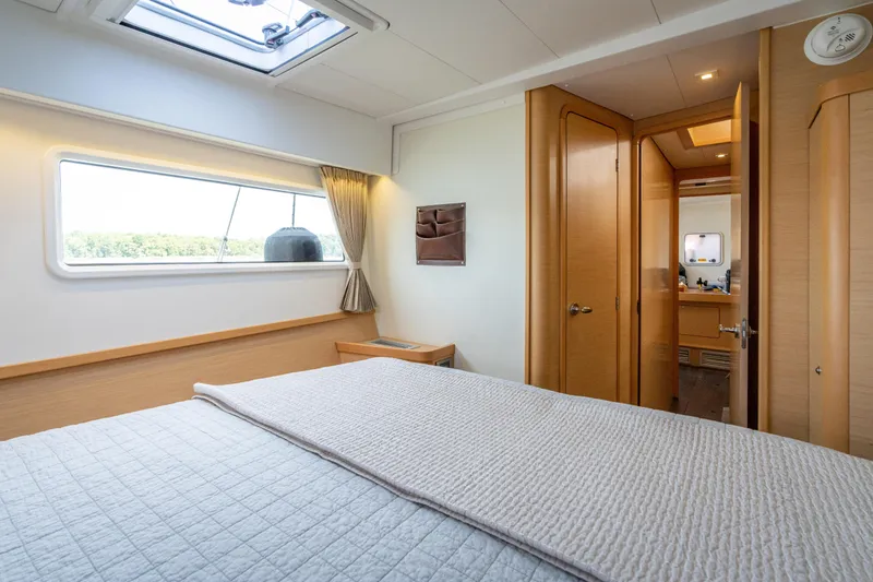 Slide: The Image of Interior of a 2017 Lagoon 42 featuring a cozy bedroom with an adjoining bathroom. - 44