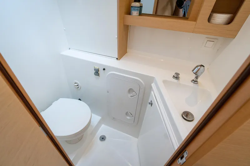 Slide: The Image of The image shows a modern boat bathroom with a toilet, sink, and wood paneling. - 49