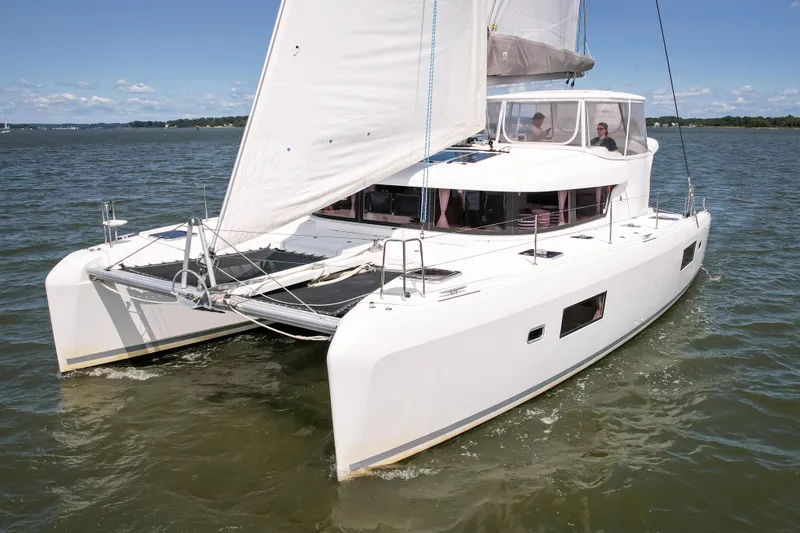 Slide: The Image of A white 2017 Lagoon 42 catamaran sails on calm waters under a blue sky. - 14
