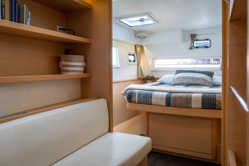 Slide: The Image of Interior of a 2017 Lagoon 42 featuring a cozy bed and wooden shelves. - 31